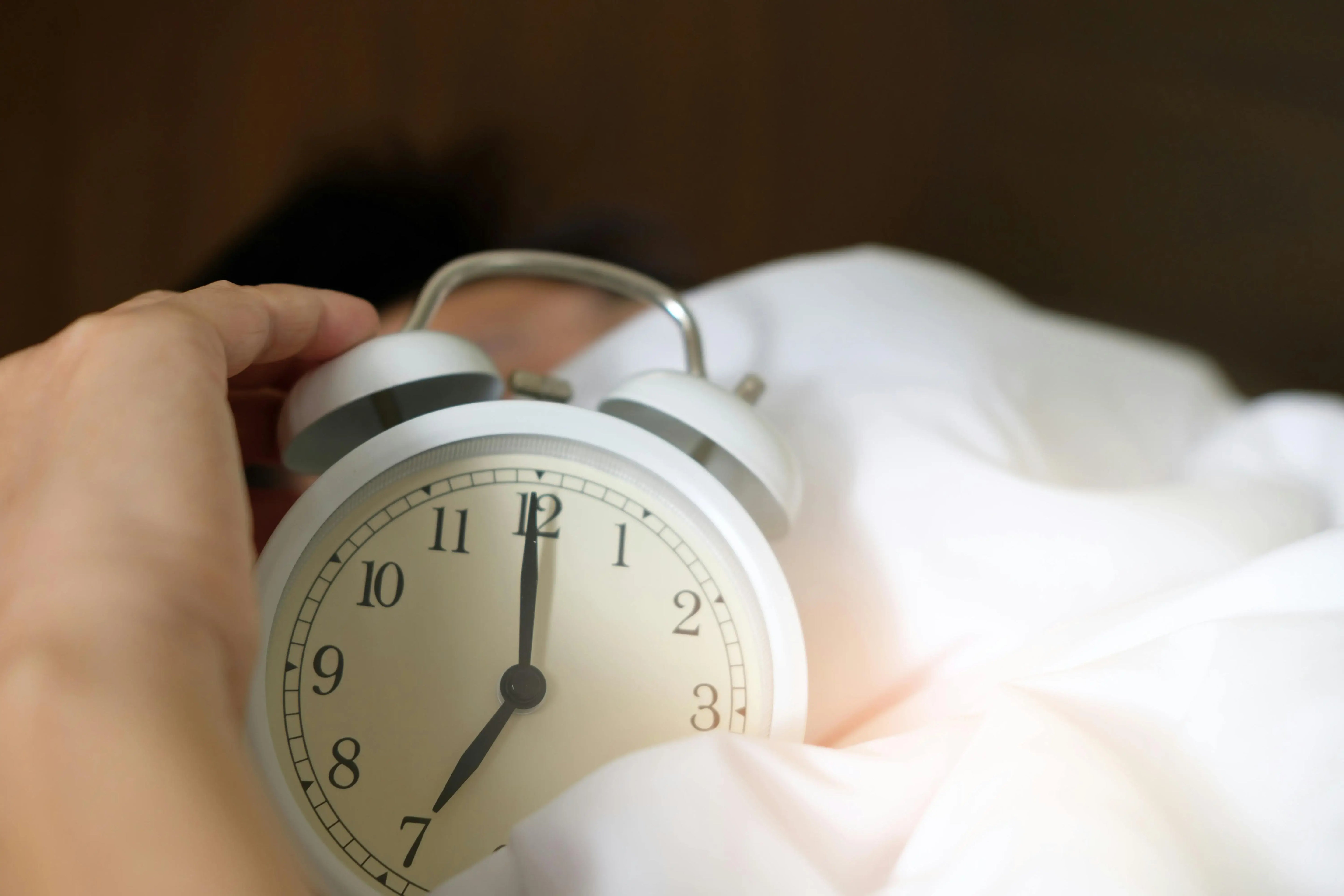 alarm clock and person sleeping with melatonin