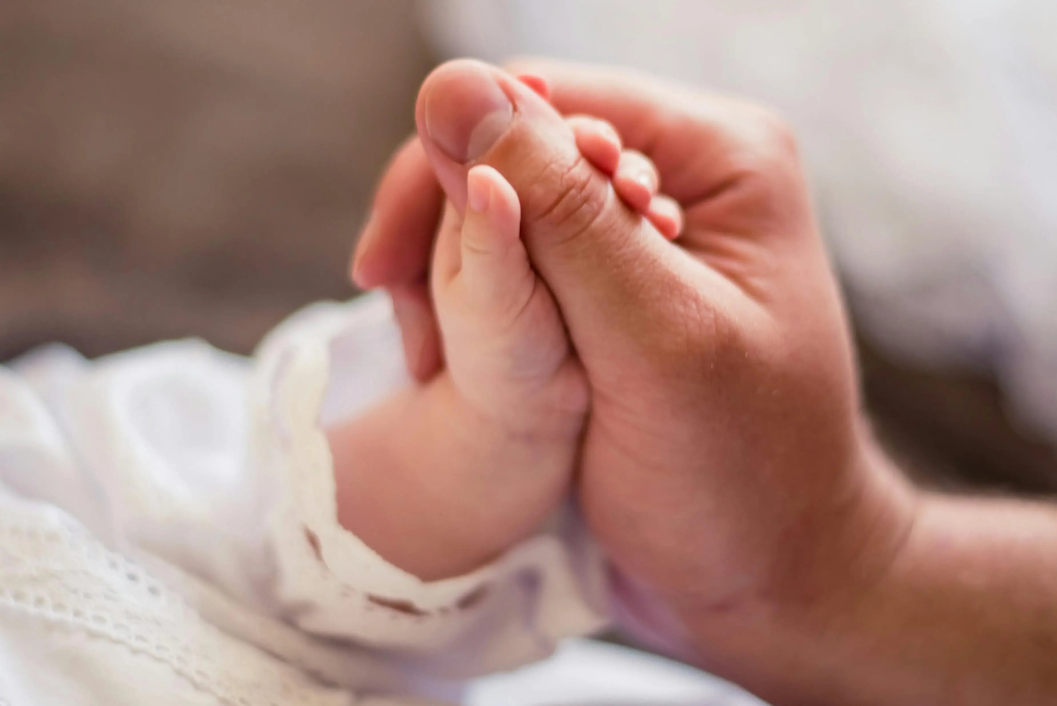 fatigued postpartum woman holding baby